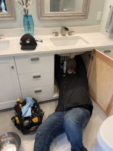 technician-fixing-plumbing-under-sink