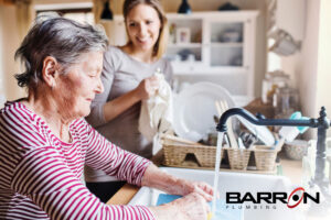 woman-using-sink-with-younger-woman-in-background-smiling